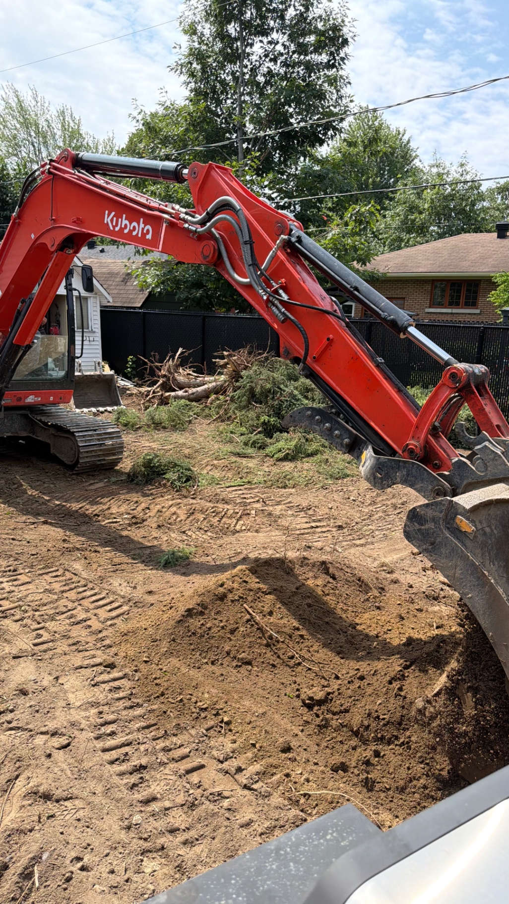 Phase excavation Projet Belmont — mini-excavatrice Kubota dégageant souches et végétation pour la préparation de la fondation.