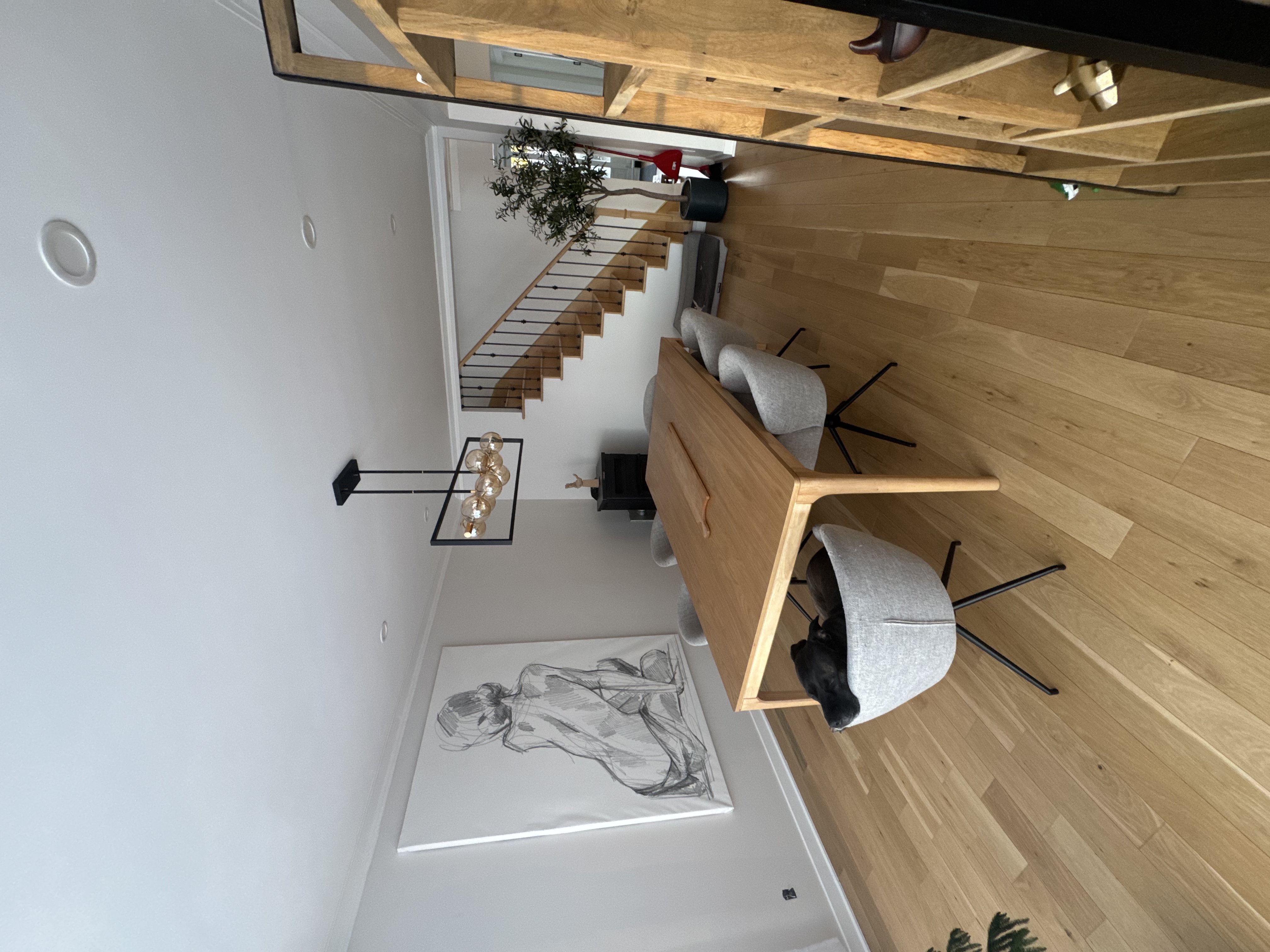 Salle à manger de la nouvelle aile Belmont, plancher de chêne, poêle à bois et escalier vers l'étage.