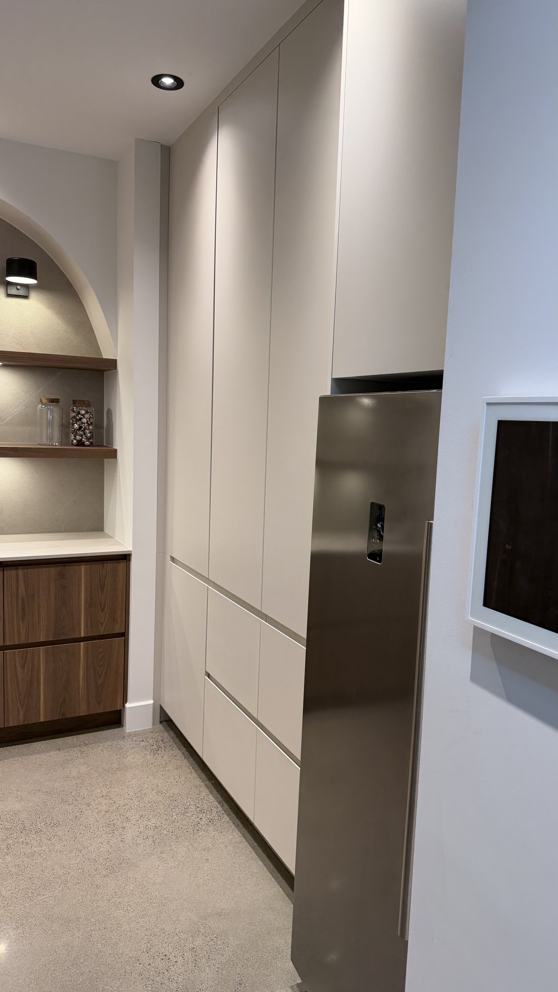Full-height white AGT PET storage columns, 30th Avenue Project, integrating the pantry's refrigerator.