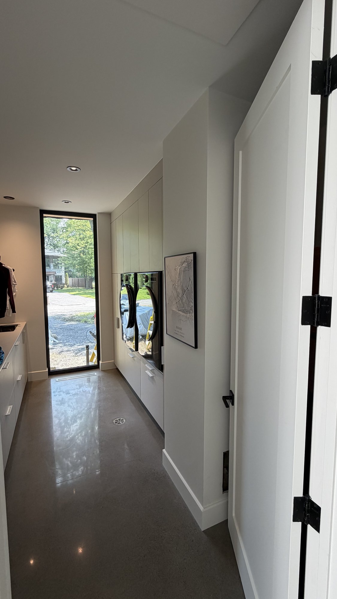 Mudroom in the 30th Avenue Project — AGT PET storage columns, built-in appliances and a full-height glazed door to the garage entry.