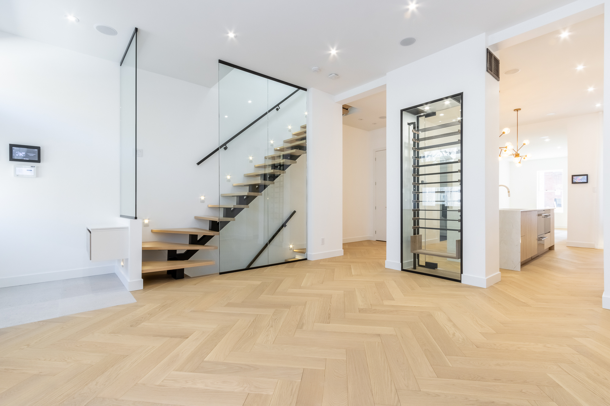 Floating oak-and-black-steel staircase and custom glazed wine cellar, Westmount residence.